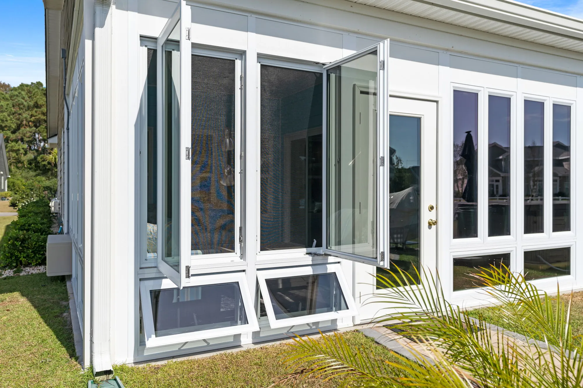 Sunroom with open casement windows and awning windows, showcasing a bright, modern design that invites airflow and natural light