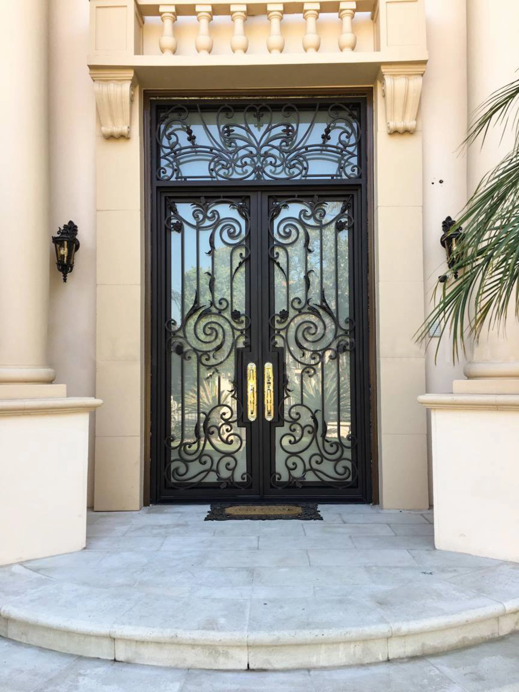Tall wrought iron double entry doors highlighting custom exterior door height in a luxury home
