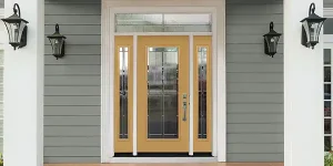 Image of fiberglass front door in yellow finish with full-lite sidelites on grey siding home