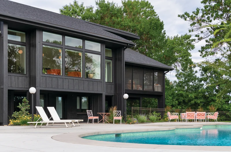 Image of best replacement window brands installed on a dark-exterior luxury home with poolside outdoor living